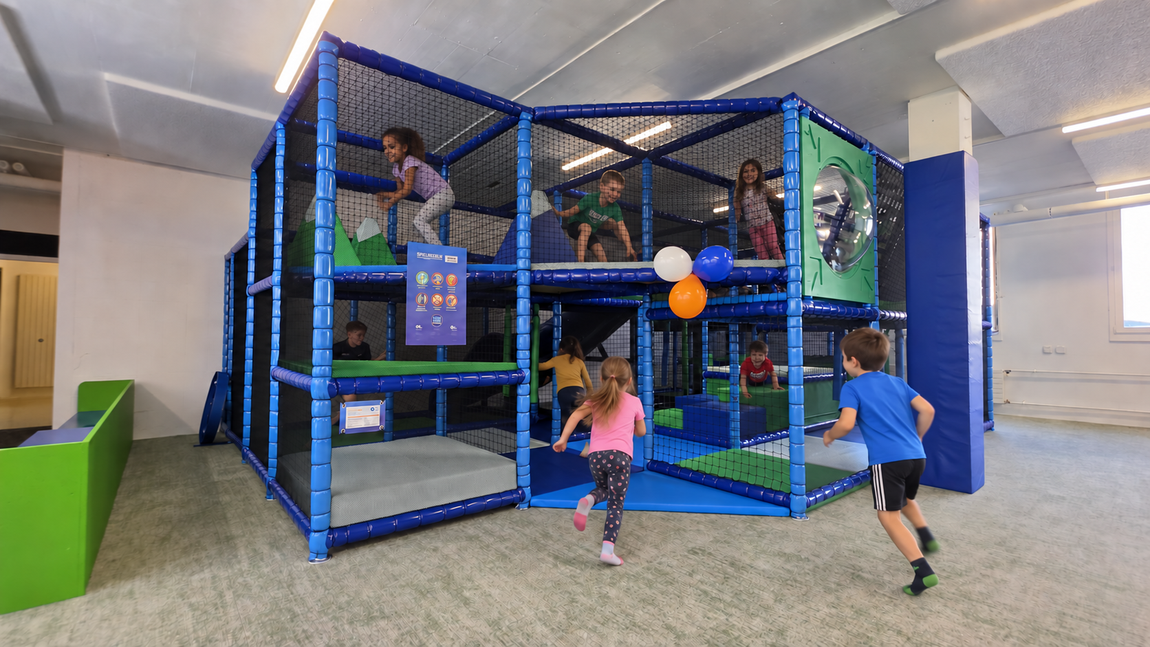 Kinder spielen in der blauen Softplay-Anlage